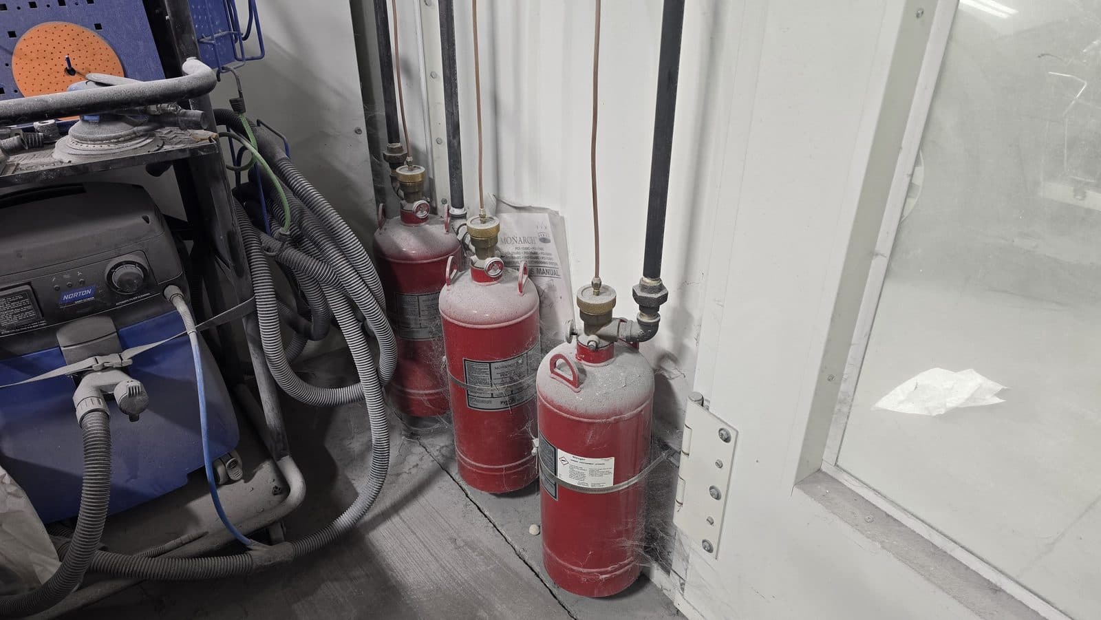 Pre-engineered industrial dry chemical suppression cylinders serving a finishing booth
